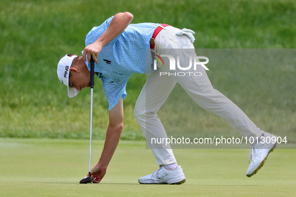 Sam Bennett of Madisonville, Texas places his ball on the 17th green during The Memorial Tournament presented by Workday at Muirfield Villag...