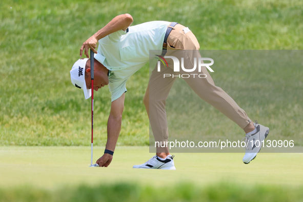 Eric Cole of Delray Beach, Florida places his ball on the 17th green during The Memorial Tournament presented by Workday at Muirfield Villag...