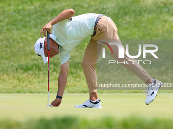 Eric Cole of Delray Beach, Florida places his ball on the 17th green during The Memorial Tournament presented by Workday at Muirfield Villag...