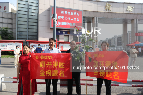  Parents hold banners to cheer for students at a national college entrance examination site in Lianyungang, Jiangsu province, China, on June...