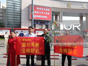  Parents hold banners to cheer for students at a national college entrance examination site in Lianyungang, Jiangsu province, China, on June...