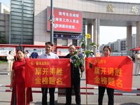  Parents hold banners to cheer for students at a national college entrance examination site in Lianyungang, Jiangsu province, China, on June...