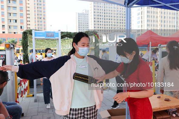  Invigilators inspect candidates entering a national college entrance examination center in Lianyungang, East China's Jiangsu province, on J...