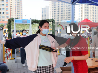  Invigilators inspect candidates entering a national college entrance examination center in Lianyungang, East China's Jiangsu province, on J...