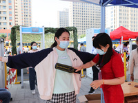  Invigilators inspect candidates entering a national college entrance examination center in Lianyungang, East China's Jiangsu province, on J...