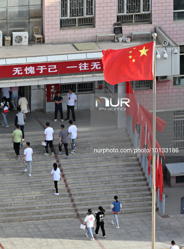  Students enter a national college entrance examination center in Bazhou, Xinjiang province, China, on June 7, 2023. 