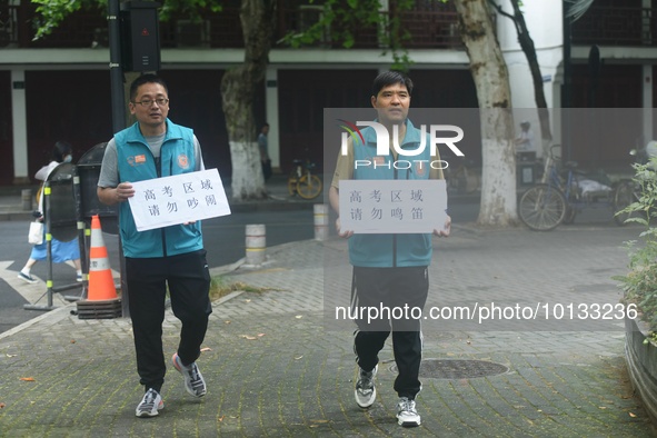 HANGZHOU, CHINA - JUNE 7, 2023 - Volunteers remind vehicles not to sound their horns near a test center for the National College entrance ex...