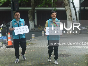 HANGZHOU, CHINA - JUNE 7, 2023 - Volunteers remind vehicles not to sound their horns near a test center for the National College entrance ex...