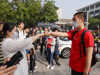 Candidates walk into a test room with admission tickets in Changzhou, Jiangsu province, China, on June 7, 2023. The 2023 National college en...