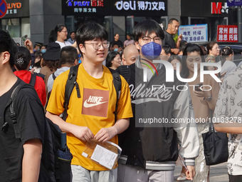 Candidates walk into a test room with admission tickets in Changzhou, Jiangsu province, China, on June 7, 2023. The 2023 National college en...