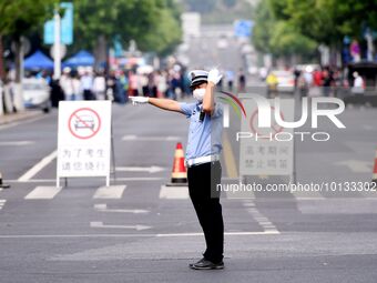 QINGDAO, CHINA - JUNE 7, 2023 - Traffic police direct traffic in front of a college entrance exam site in Qingdao, Shandong province, China,...