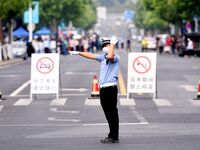 QINGDAO, CHINA - JUNE 7, 2023 - Traffic police direct traffic in front of a college entrance exam site in Qingdao, Shandong province, China,...