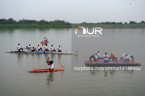 Participants perform yoga on the surface Yamuna River to mark the International Yoga Day celebrations on June 21, 2023 in New Delhi, India....