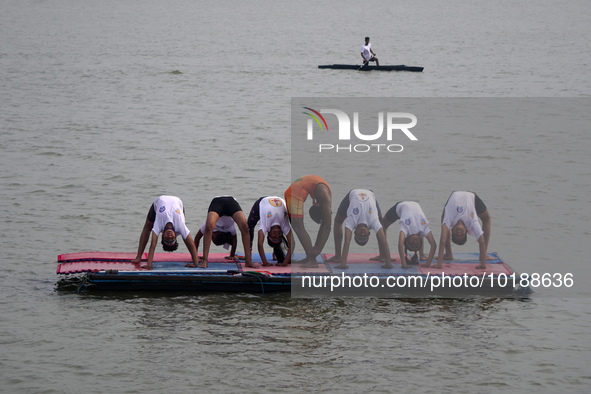 Participants perform yoga on the surface Yamuna River to mark the International Yoga Day celebrations on June 21, 2023 in New Delhi, India....