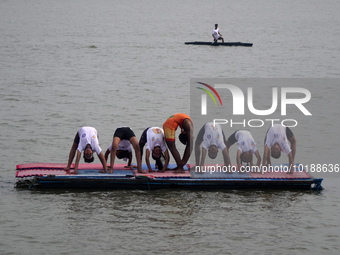 Participants perform yoga on the surface Yamuna River to mark the International Yoga Day celebrations on June 21, 2023 in New Delhi, India....