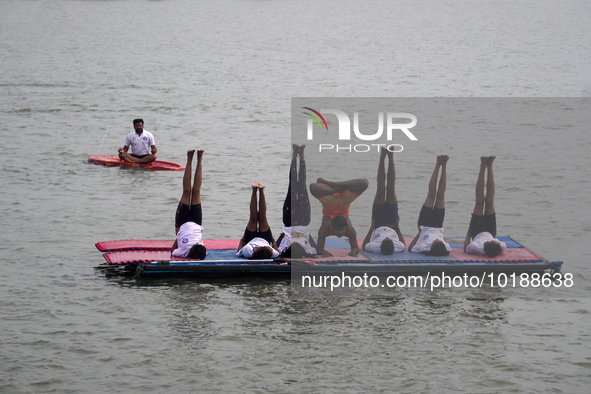 Participants perform yoga on the surface Yamuna River to mark the International Yoga Day celebrations on June 21, 2023 in New Delhi, India....