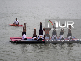 Participants perform yoga on the surface Yamuna River to mark the International Yoga Day celebrations on June 21, 2023 in New Delhi, India....