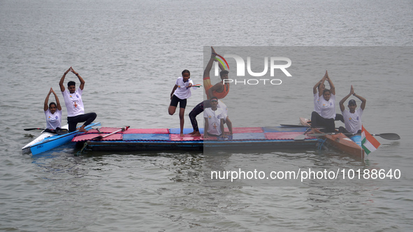 Participants perform yoga on the surface Yamuna River to mark the International Yoga Day celebrations on June 21, 2023 in New Delhi, India....