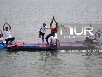 Participants perform yoga on the surface Yamuna River to mark the International Yoga Day celebrations on June 21, 2023 in New Delhi, India....