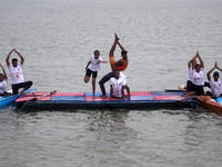 Participants perform yoga on the surface Yamuna River to mark the International Yoga Day celebrations on June 21, 2023 in New Delhi, India....