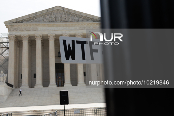 A demonstrator passes the Supreme Court with a sign in Washington, D.C. on June 30, 2023 following the Supreme Court's ruling that President...