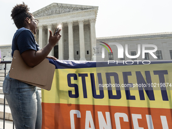 Satra Tayloir's phone catches the sun as she celebrates at the Supreme Court after it rules thta the plaintiff does not have standing to cha...