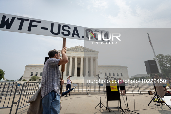 A conspiracy theorist stands in front of Supreme Court prior to a protest of the Court's ruling against President Joe Biden’s student-debt r...