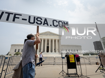 A conspiracy theorist stands in front of Supreme Court prior to a protest of the Court's ruling against President Joe Biden’s student-debt r...