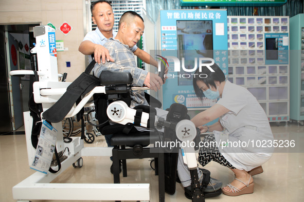 

Medical staff are fastening a patient to a lower limb rehabilitation robot in Chongqing, China, on July 4, 2023. 