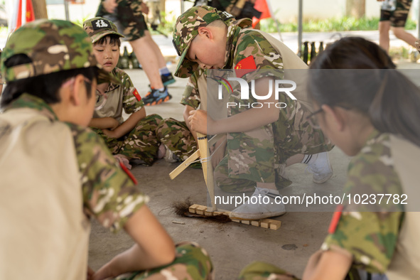 

Children are drilling wood to make fire at a military summer camp in Hefei, Anhui Province, China on July 5, 2023. 