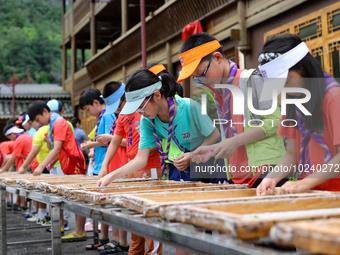 

Primary school students from Shanghai are experiencing making herbal paper at an ancient papermaking workshop in Shiqiao village, Nangao T...