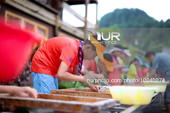 

Primary school students from Shanghai are experiencing making herbal paper at an ancient papermaking workshop in Shiqiao village, Nangao T...