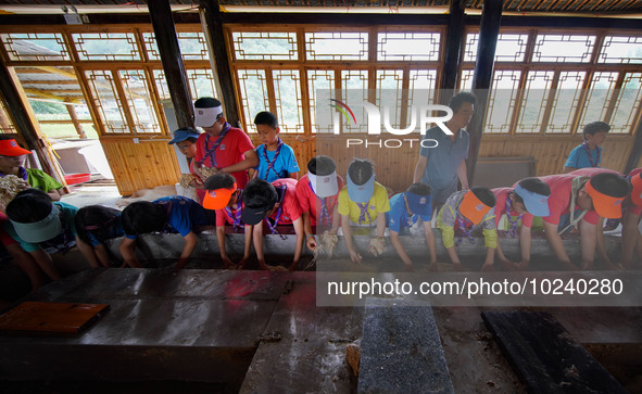 

Primary school students from Shanghai are experiencing ancient papermaking skills in Shiqiao Village, Nangao Township, Danzhai County, Qia...