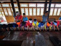 

Primary school students from Shanghai are experiencing ancient papermaking skills in Shiqiao Village, Nangao Township, Danzhai County, Qia...