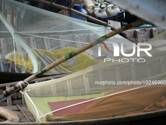 Boatmans sleep under a mosquito nets on their boats to protect them from dengue at the bank of the Buriganga River in Dhaka, Bangladesh, on...