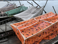 Boatmans sleep under a mosquito nets on their boats to protect them from dengue at the bank of the Buriganga River in Dhaka, Bangladesh, on...