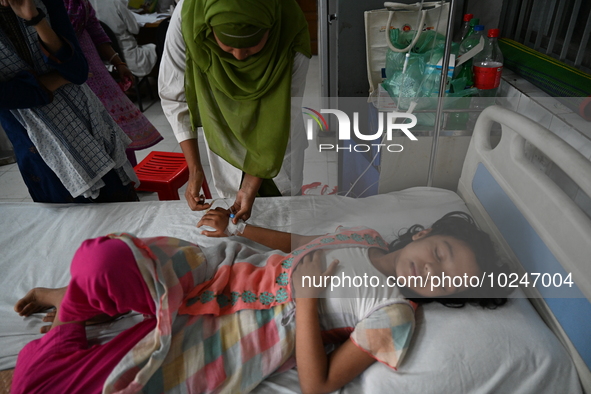 A nurse tends to a child suffering from dengue fever receive treatment inside the Dhaka Child Hospital admission section in Dhaka, Banglades...