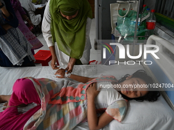 A nurse tends to a child suffering from dengue fever receive treatment inside the Dhaka Child Hospital admission section in Dhaka, Banglades...