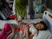 A nurse tends to a child suffering from dengue fever receive treatment inside the Dhaka Child Hospital admission section in Dhaka, Banglades...