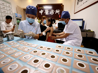 

A doctor at a traditional Chinese medicine clinic is applying "Sanfu stickers" to a child in Zaozhuang, Shandong Province, China on July 1...