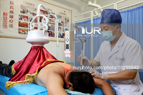 

A doctor at a traditional Chinese medicine clinic is performing suspension moxibustion and pot moxibustion treatments for citizens in Zaoz...