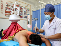 

A doctor at a traditional Chinese medicine clinic is performing suspension moxibustion and pot moxibustion treatments for citizens in Zaoz...