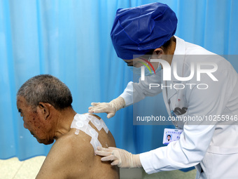 

A doctor at a traditional Chinese medicine clinic is applying "Sanfu stickers" to an elderly person in Zaozhuang, Shandong Province, China...