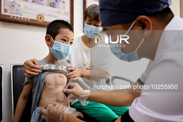 

A doctor at a traditional Chinese medicine clinic is applying "Sanfu stickers" to a child in Zaozhuang, Shandong Province, China on July 1...