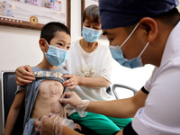 

A doctor at a traditional Chinese medicine clinic is applying "Sanfu stickers" to a child in Zaozhuang, Shandong Province, China on July 1...