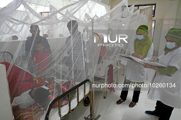 Nurse treats a patient covered with mosquito nets suffering from dengue fever rest inside the 'Shaheed Suhrawardy' Medical Colleague Hospita...