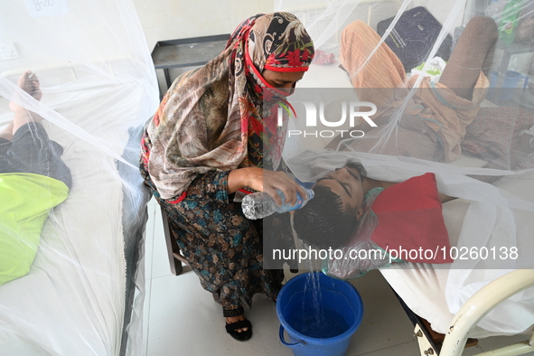 A relative pours water on the head of a dengue patient who are suffering from dengue fever rest inside the 'Shaheed Suhrawardy' Medical Coll...