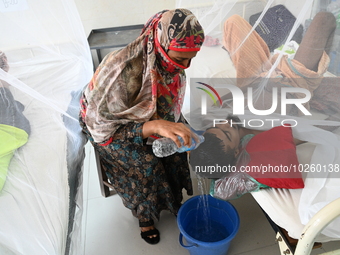 A relative pours water on the head of a dengue patient who are suffering from dengue fever rest inside the 'Shaheed Suhrawardy' Medical Coll...