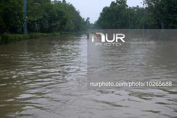 A man takes a selfie as he wades through the flooded carriageway of a road, after a rise in the waters of the river Yamuna due to heavy mons...