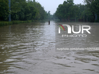 A man takes a selfie as he wades through the flooded carriageway of a road, after a rise in the waters of the river Yamuna due to heavy mons...